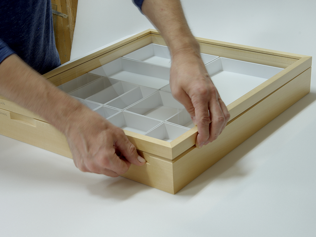 Place your thumb on the bottom of the relief and use your index and middle fingers to pry the lid in the right corner of thedrawer.